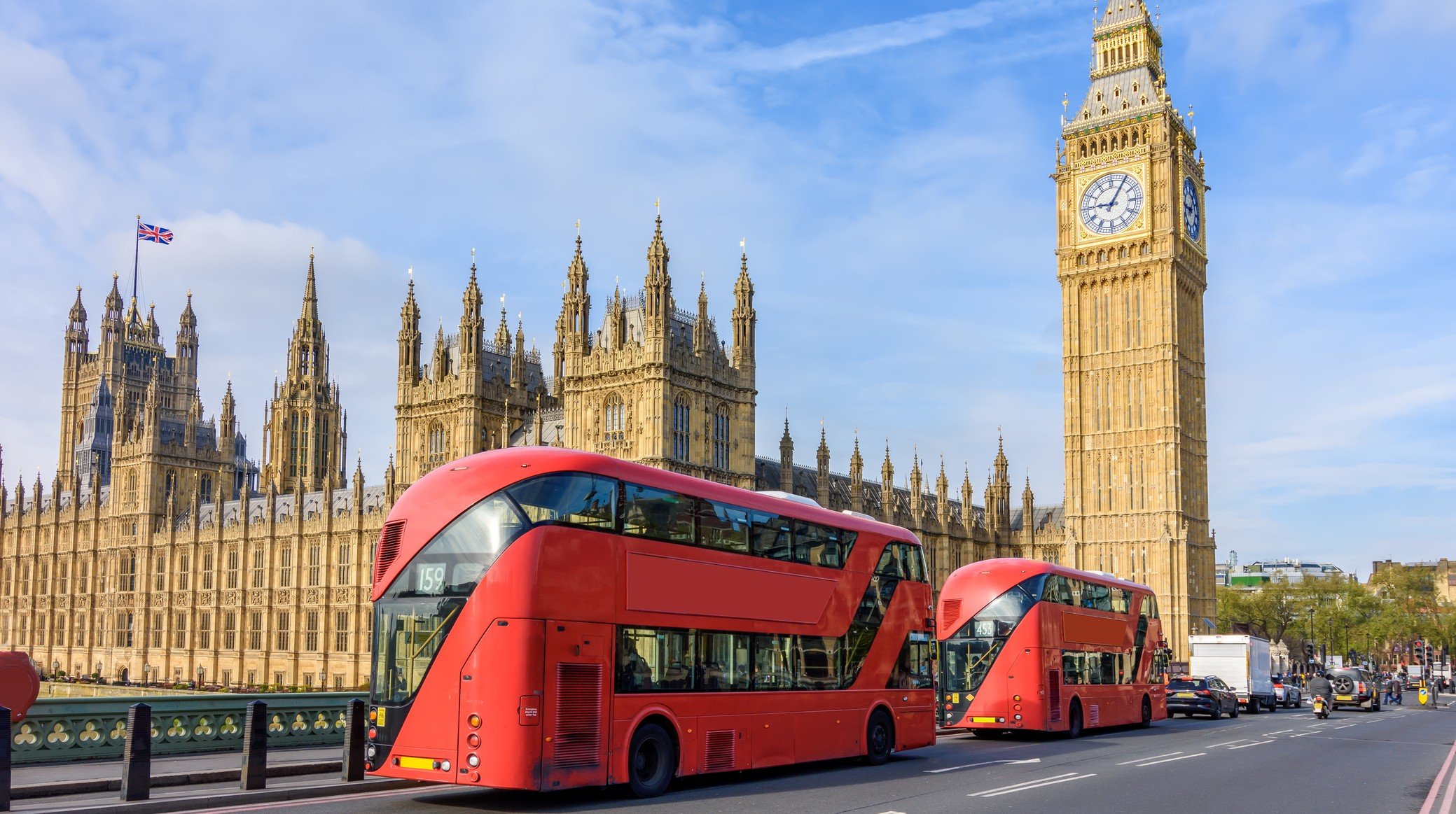 Houses of Parliament with Big Ben and double-decker buses on Westminster bridge