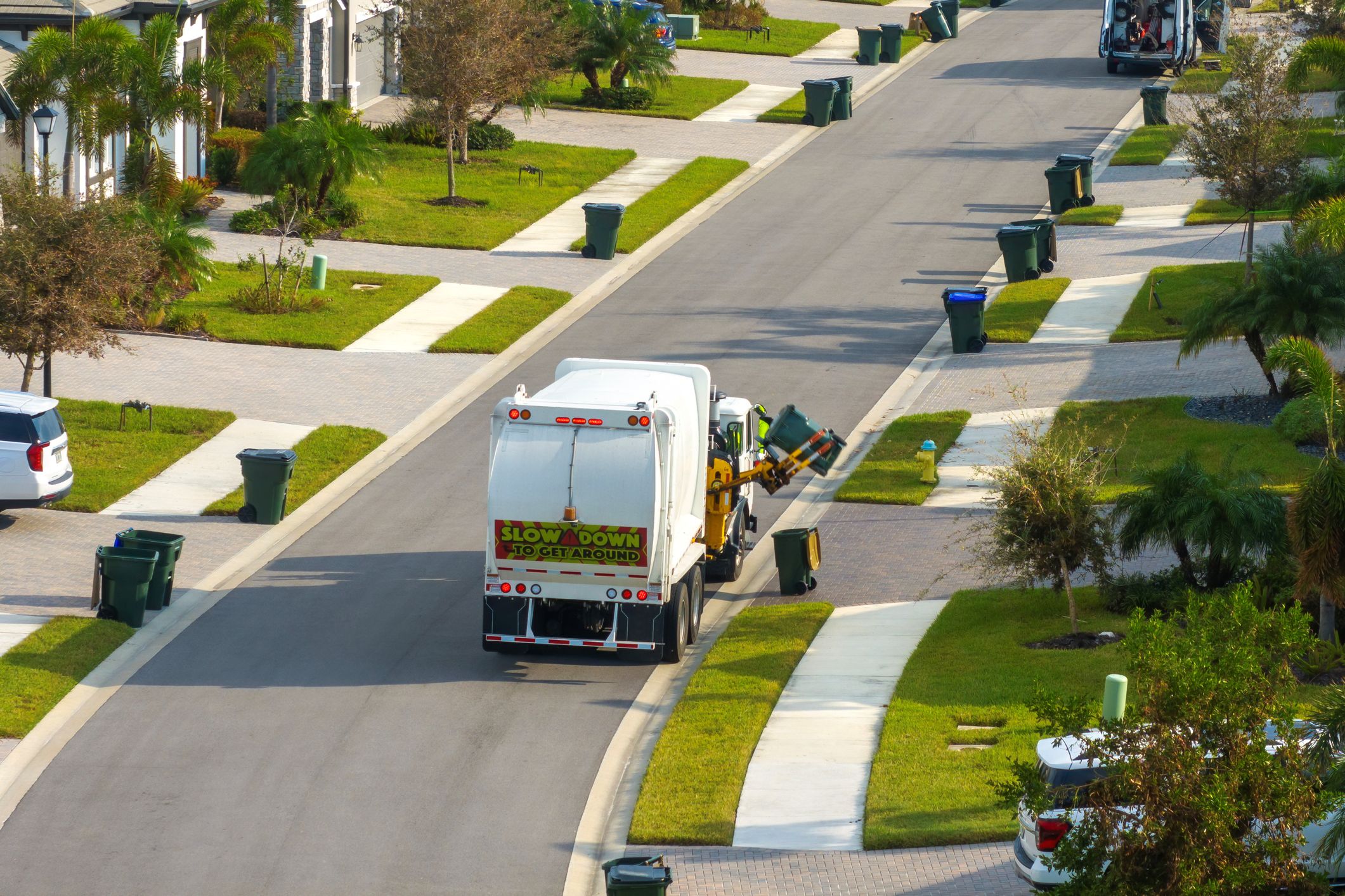 Garbage truck picking up trash on suburban street