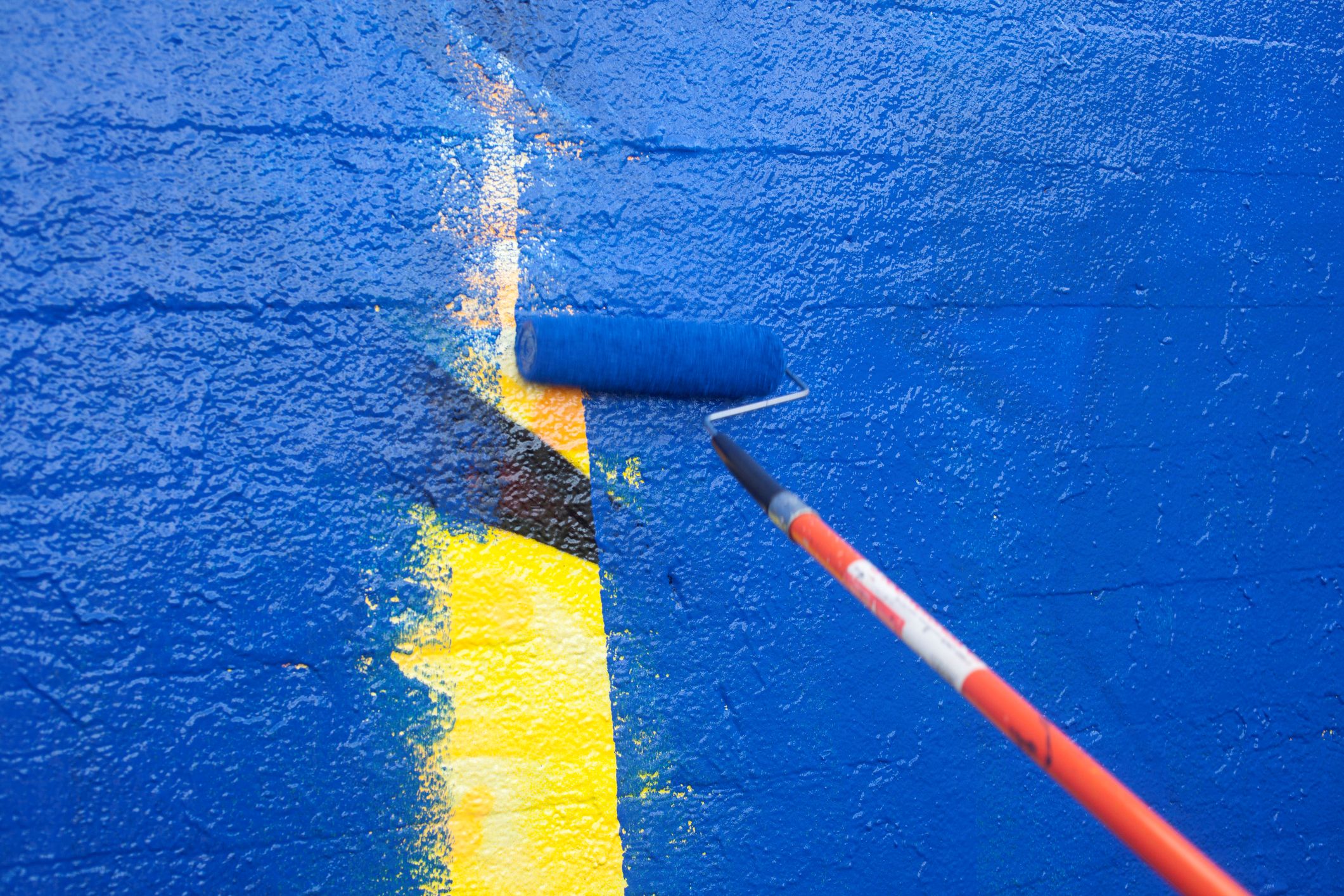 Painting over a mural with blue paint