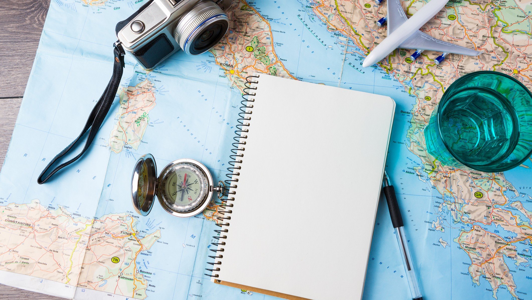 travel tourism agency table mockup tools compass glass of water note pad pen