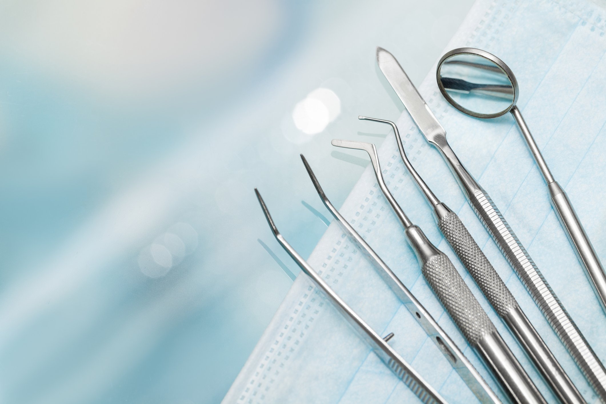 A set of mental dentistry tools sits on a face mask