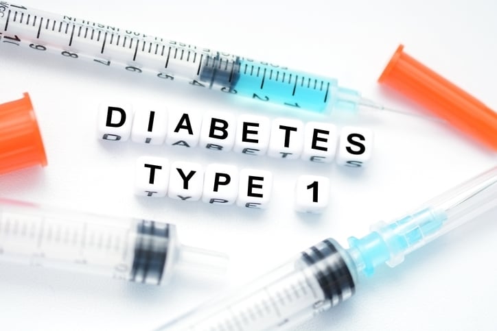 Small white blocks with black text that say Diabetes Type 1 in all caps surrounded by syringes containing a blue liquid th