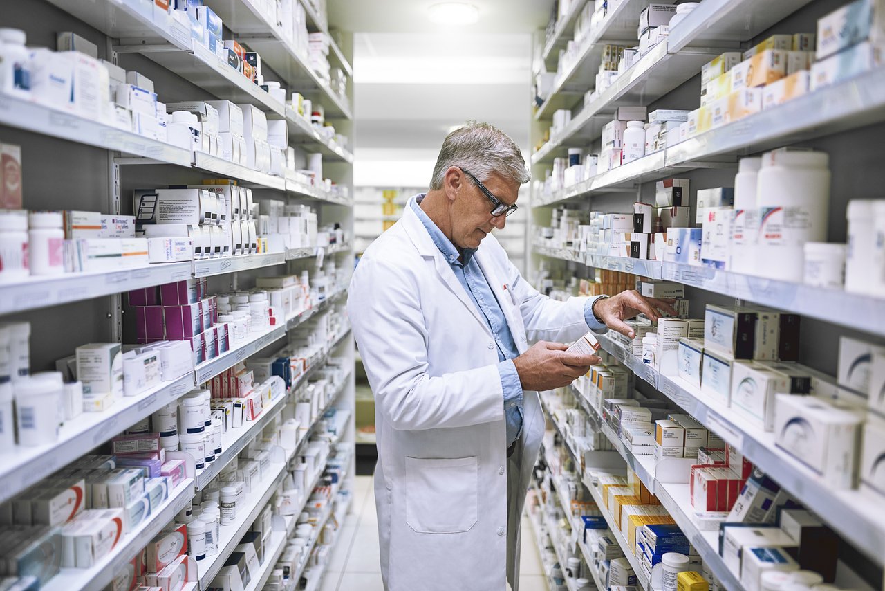 pharmacist looking at medication stock on shelves