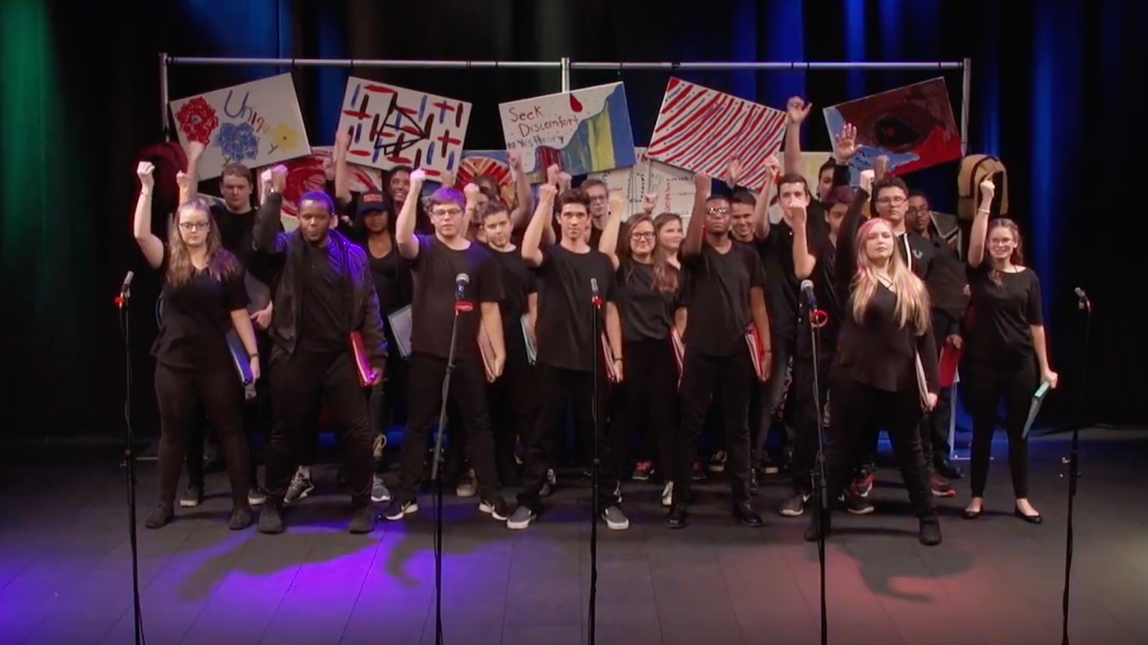 Young hemophilia patients onstage with fists in the air