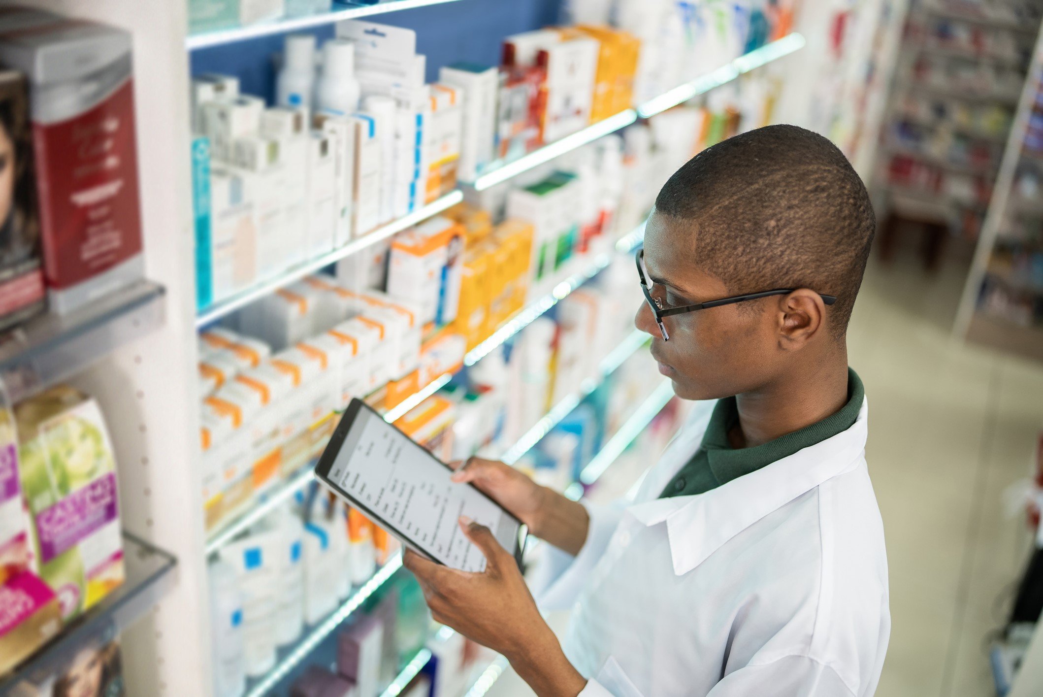 Young pharmacist checking the shelves with a digital tablet at the pharmacy - stock photo FG TradeGetty Images
