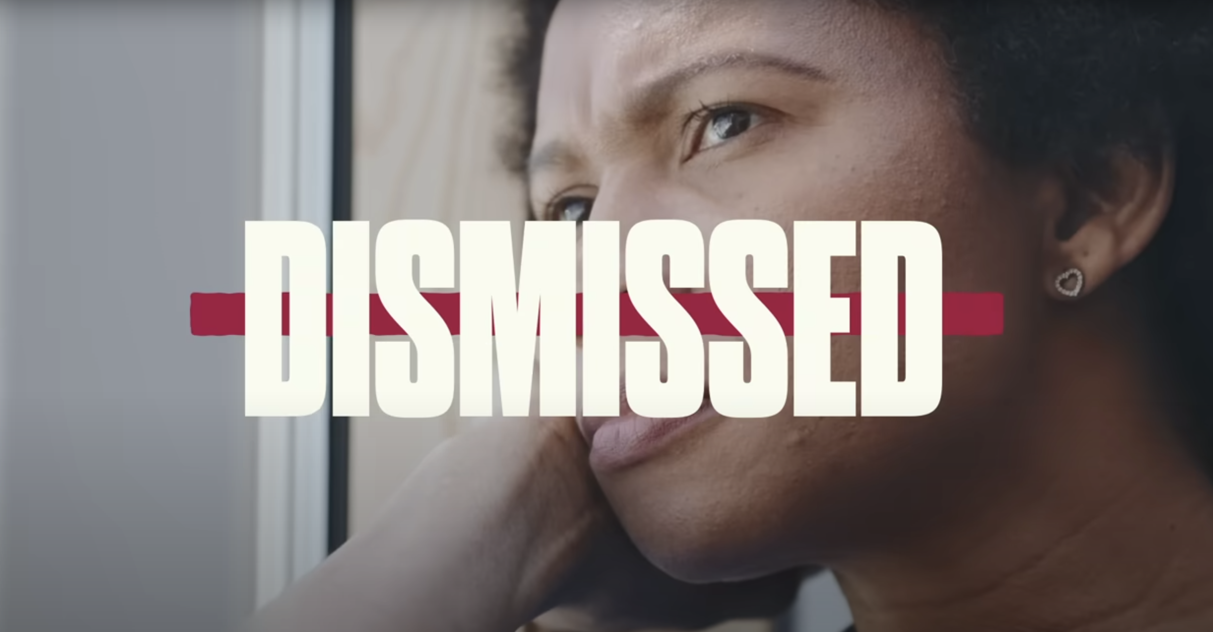 A screenshot from the Womens Heart Alliances heart attack PSA showing the word dismissed over the face of a woman