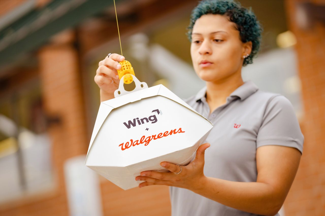 Walgreens employee attaches order to a Wing drone
