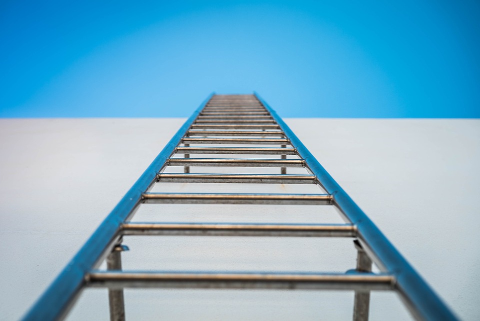 A ladder going up a side of a wall to the sky