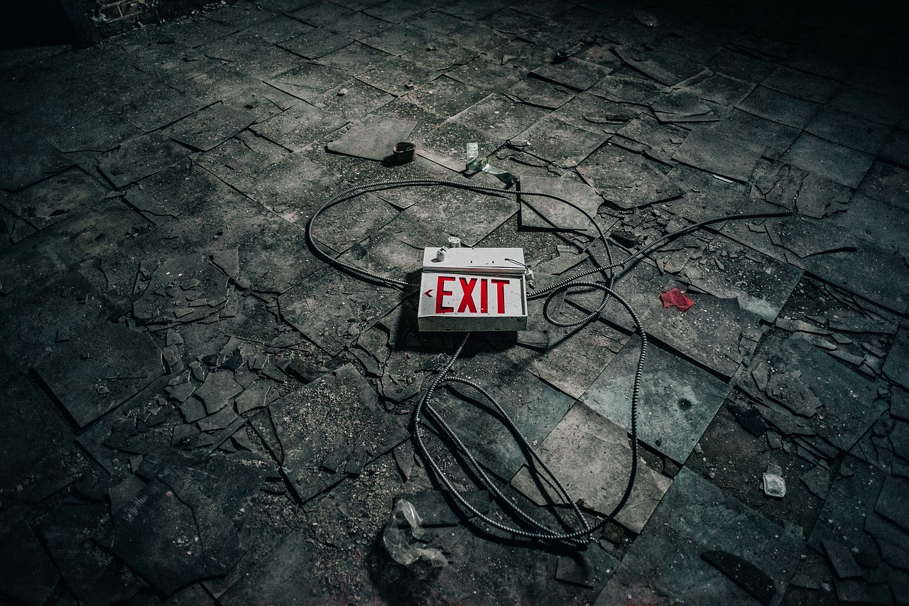 Exit sign on floor amid wreckage