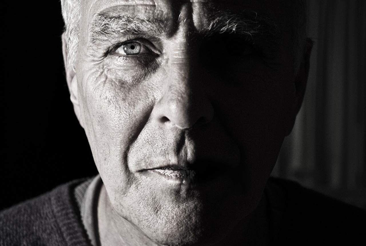 Black and white photo of old man half of face in shadow