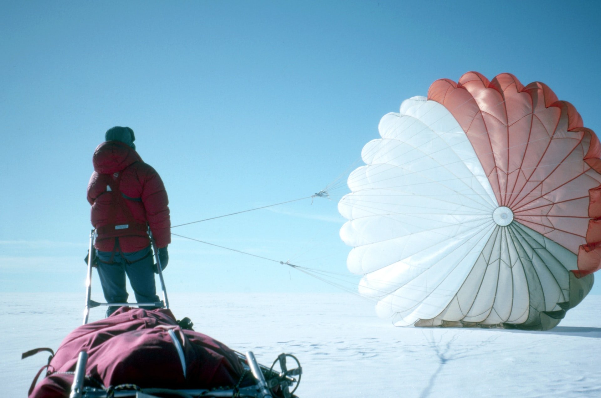 Person and parachite after landing in snow 