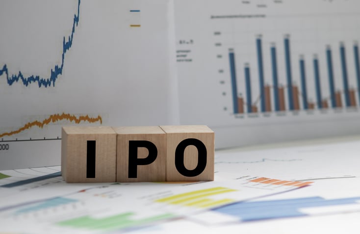 Financial documents next to blocks that spell IPO