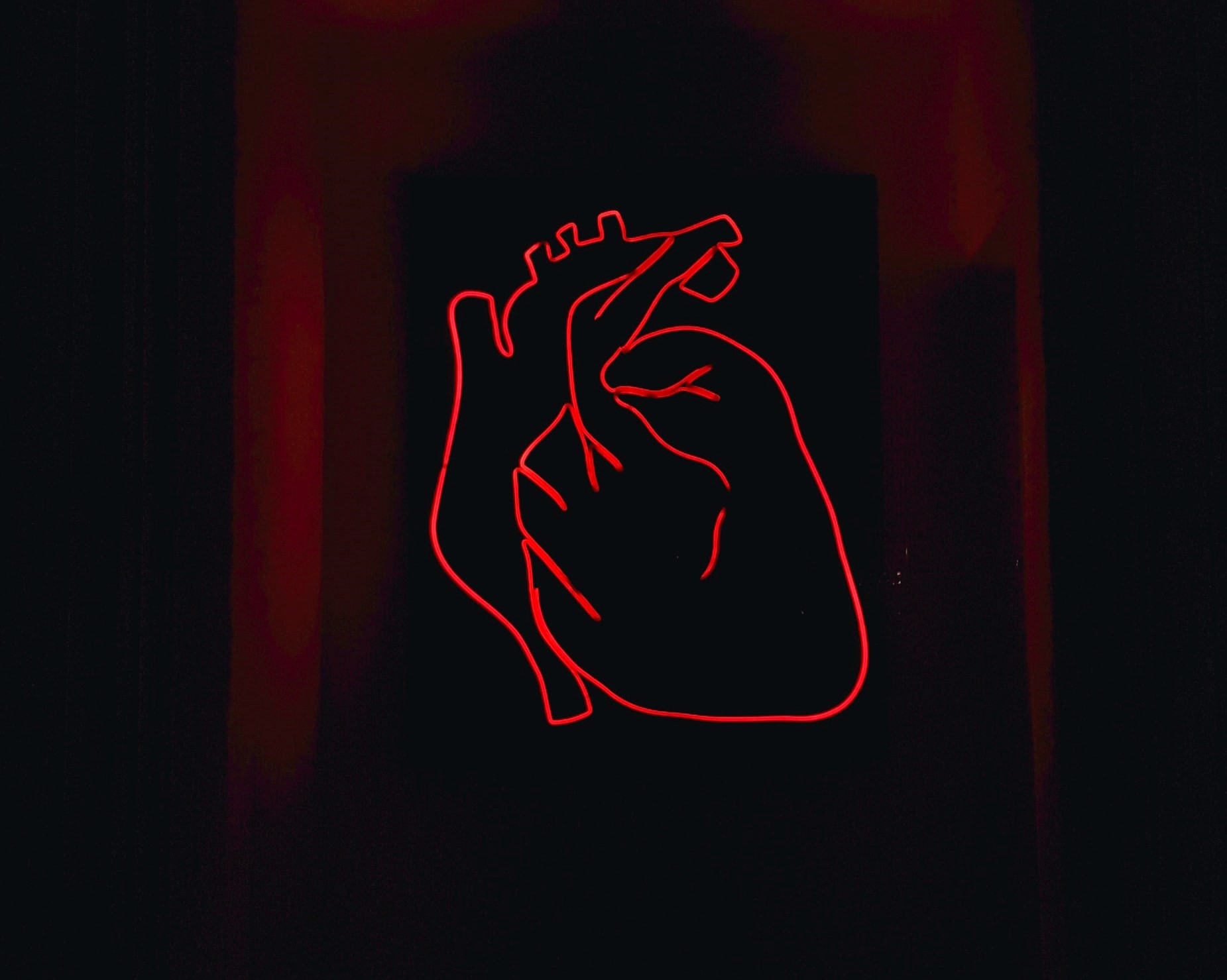 neon red heart outline on black background