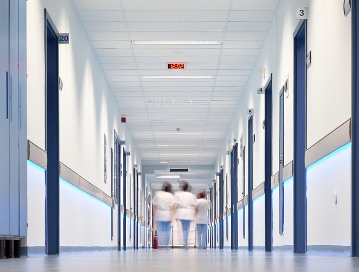Three nurses walking down a hospital corridor