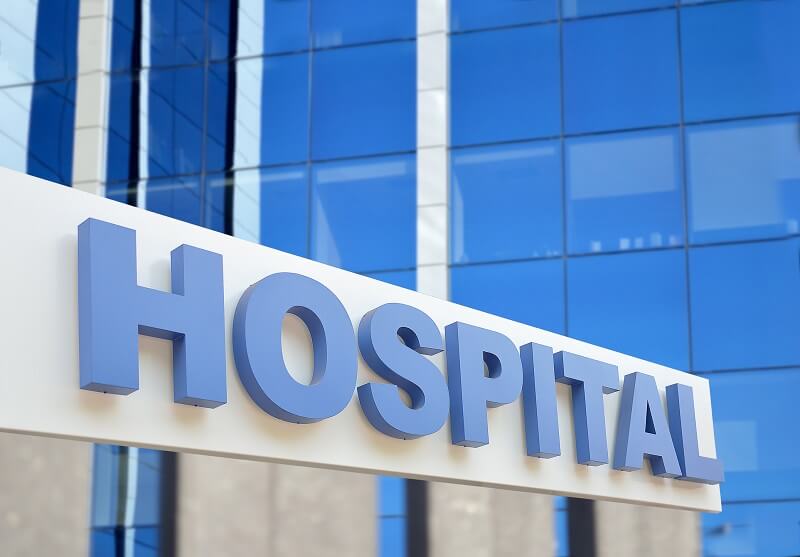 A blue hospital sign on the side of a building
