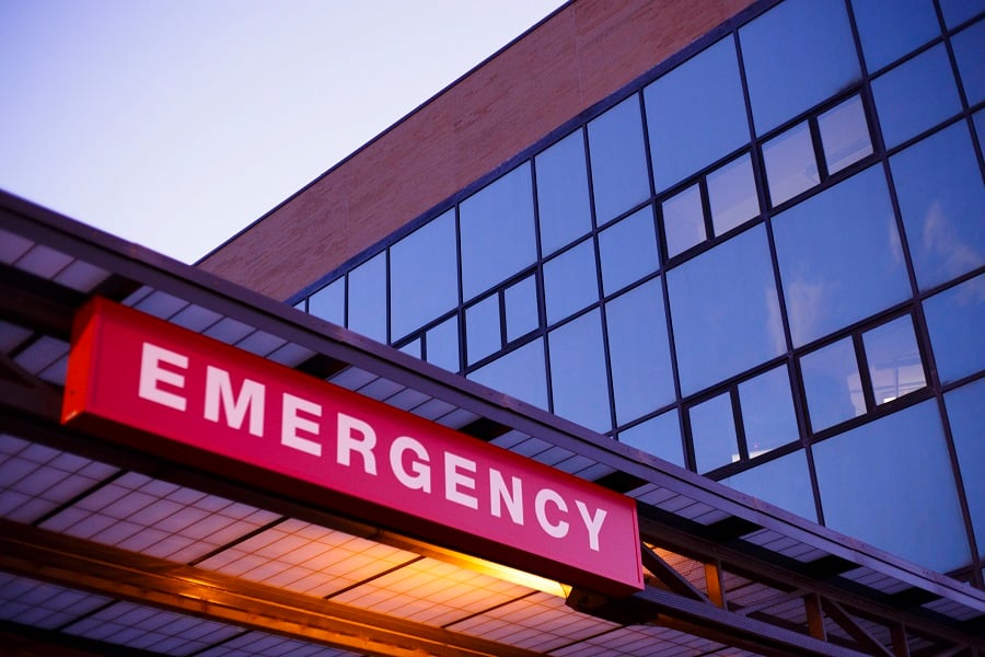 A lighted emergency room sign outside of a hospital