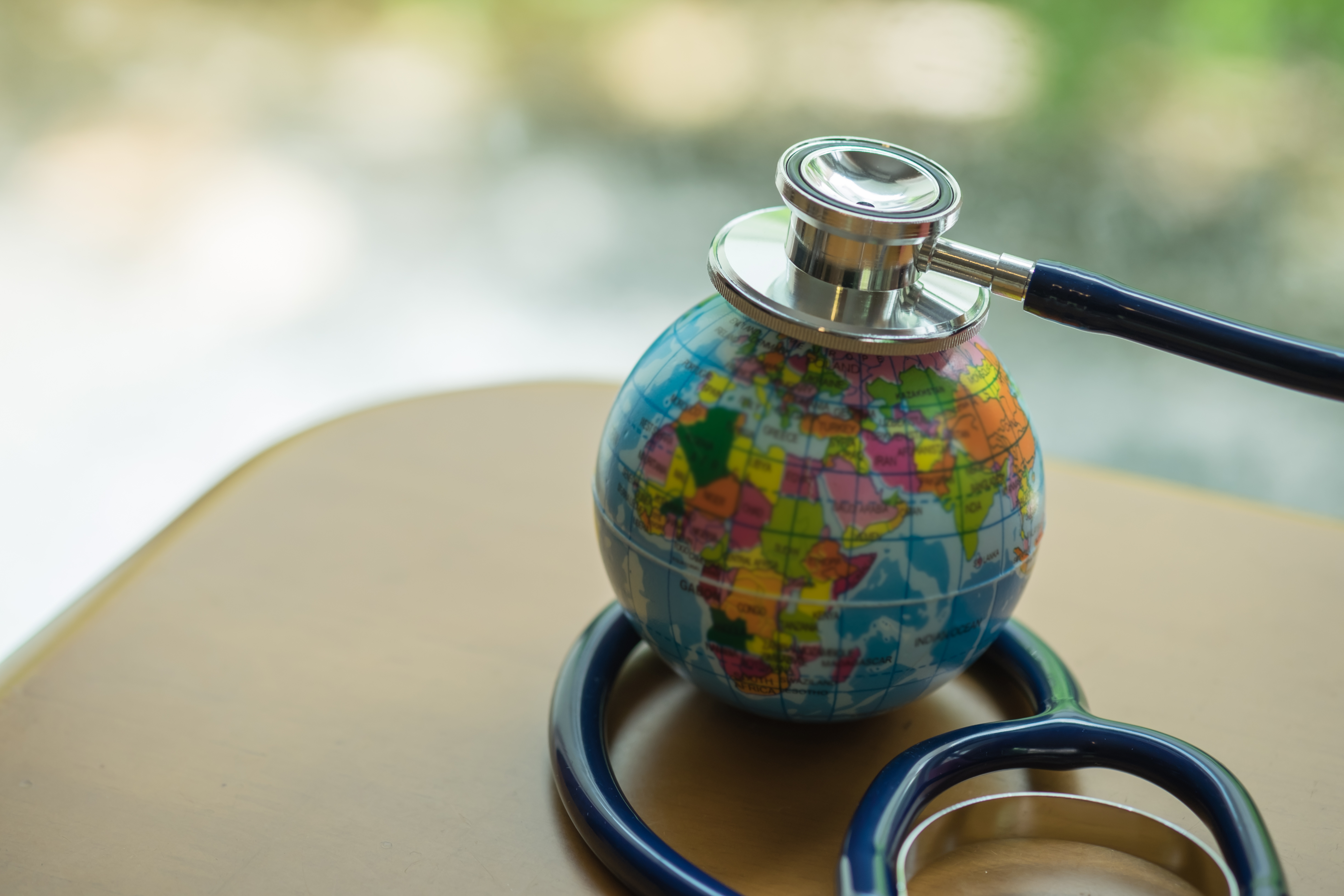 Tiny globe sitting on a table with a stethoscope on top of it
