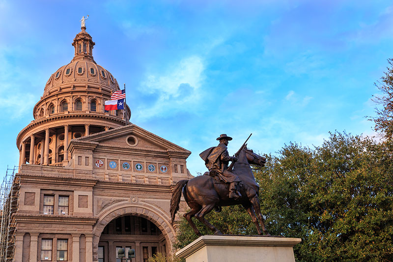 The Texas Ranger statue in front of the Texas Capitol building in Austin TX