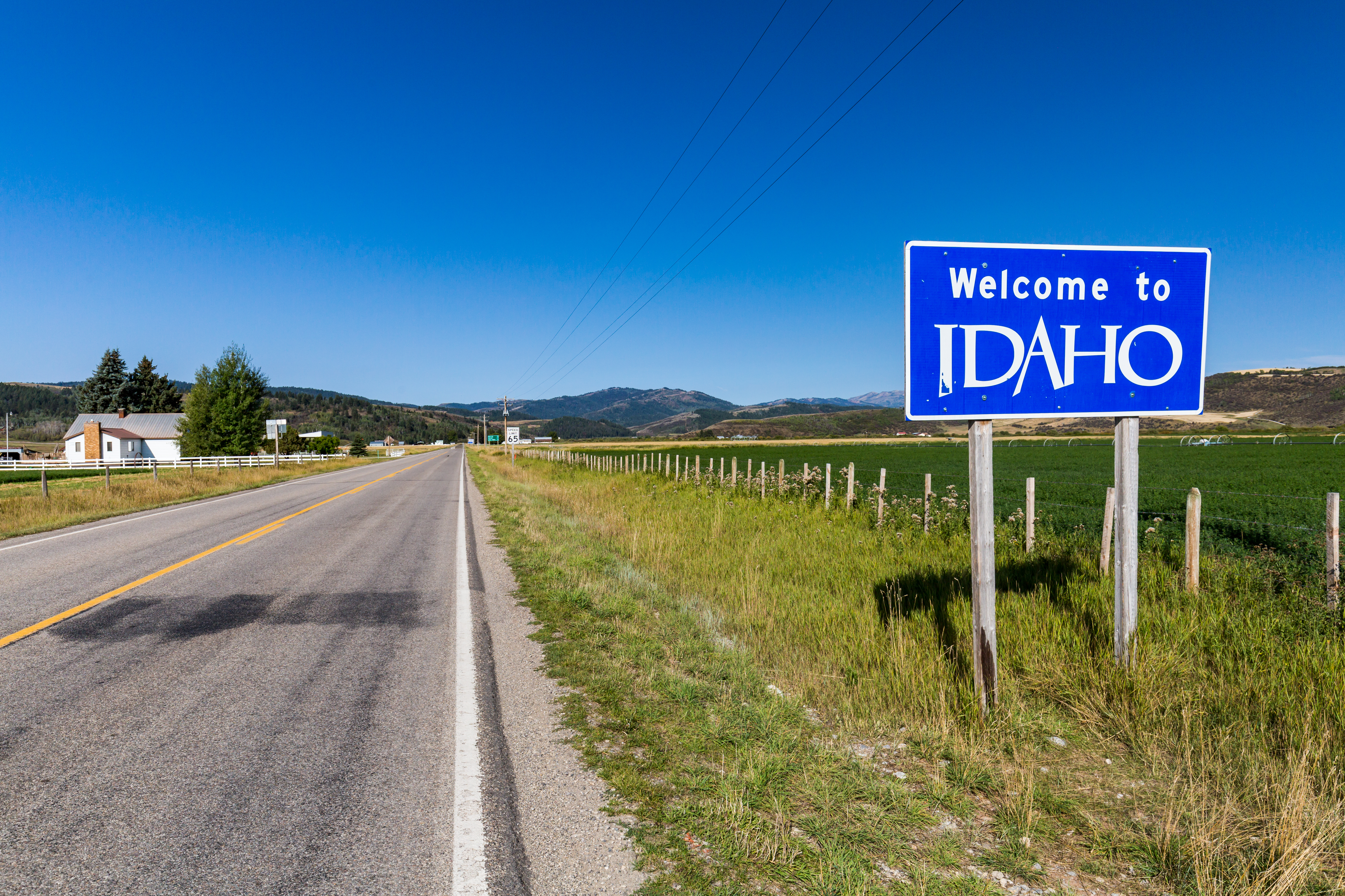 A sign next to a road reading Welcome to Idaho