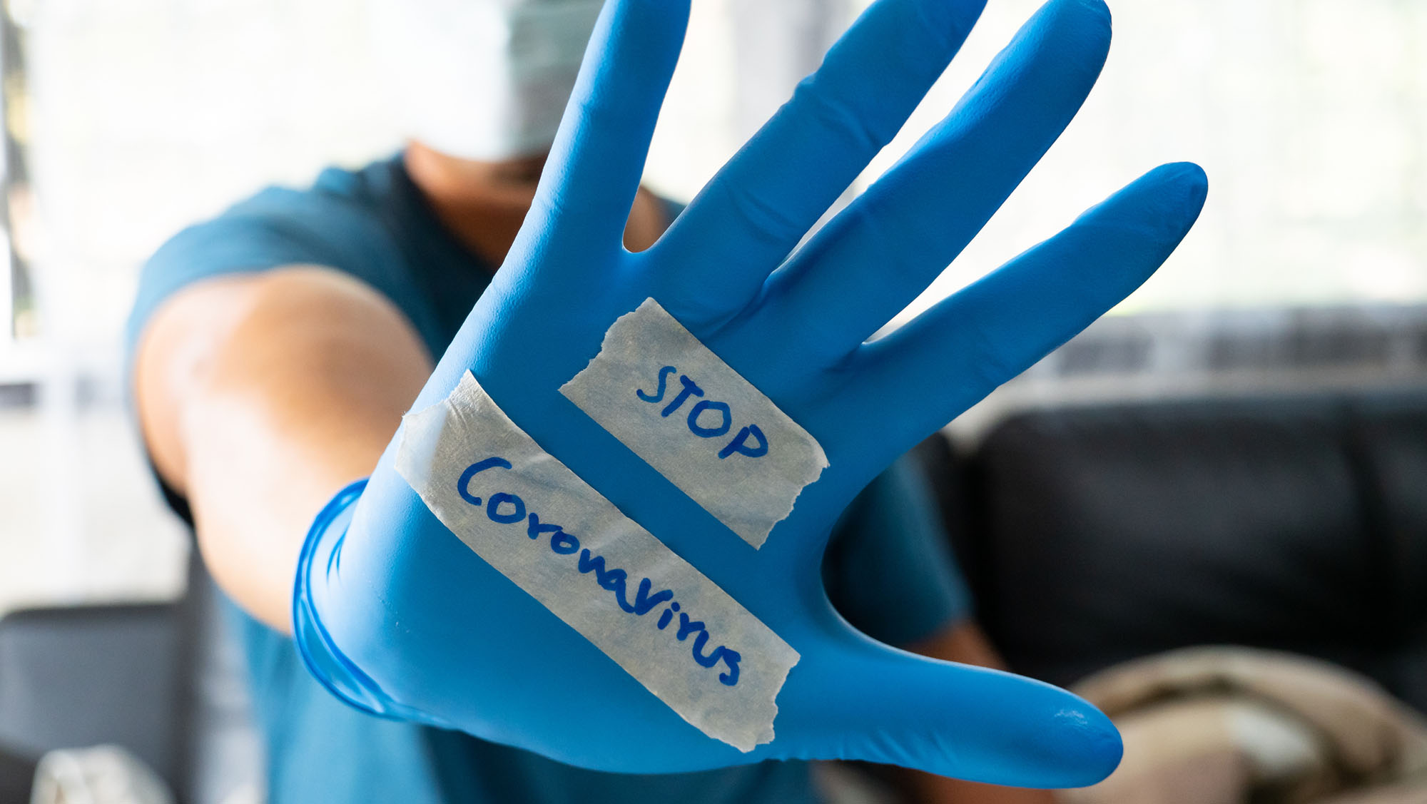 Stop coronavirus message on a gloved hand