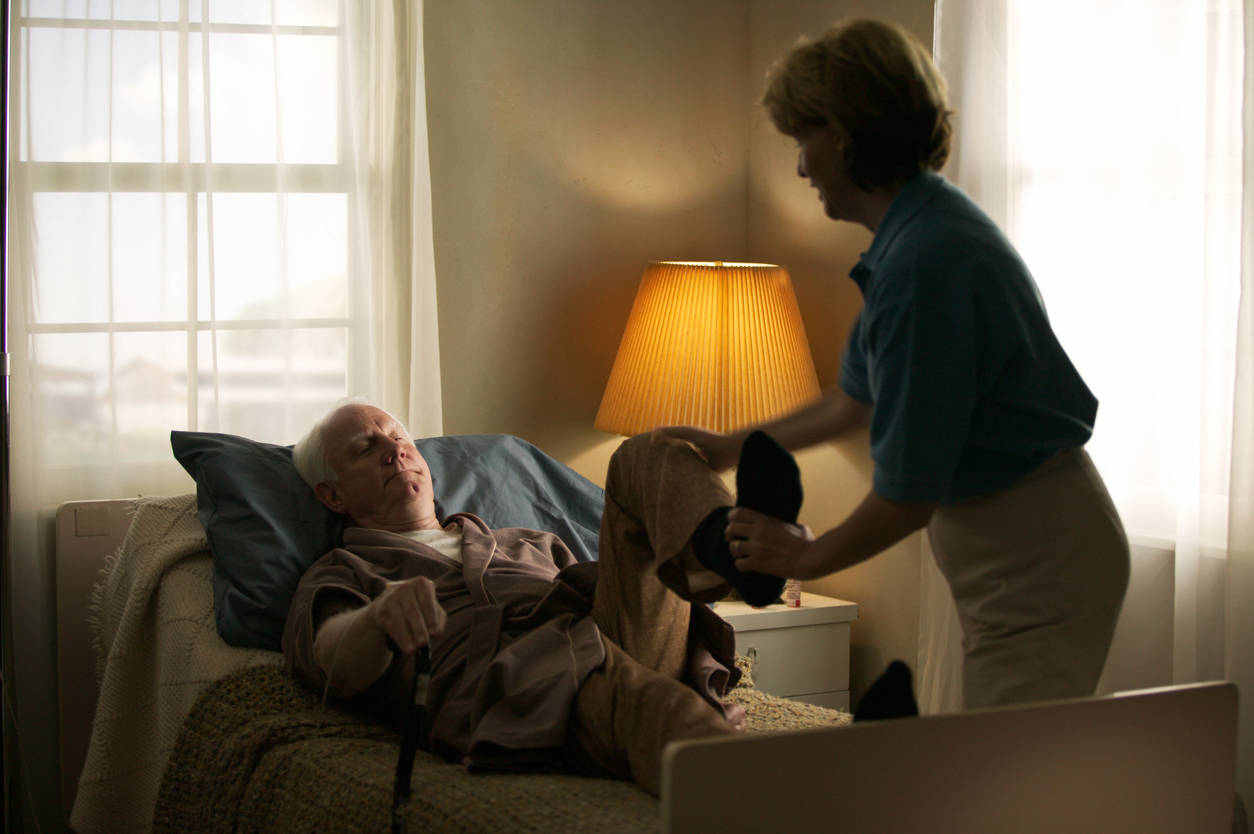 Home care nurse giving patient physical therapy