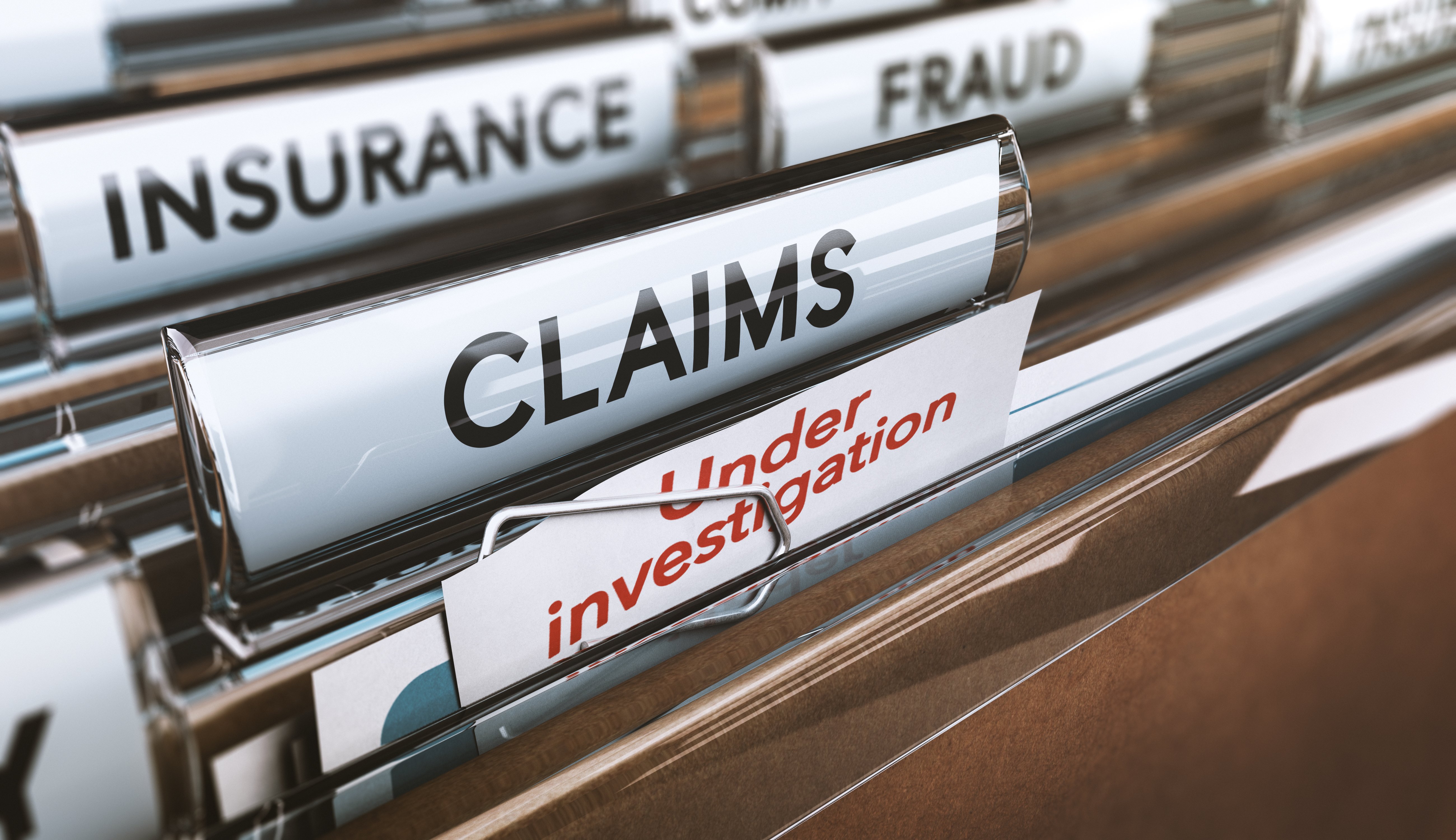File folders labeled insurance fraud claims and under investigation