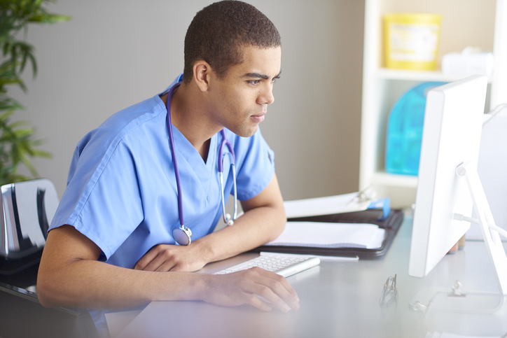A male medical student studies at a computer