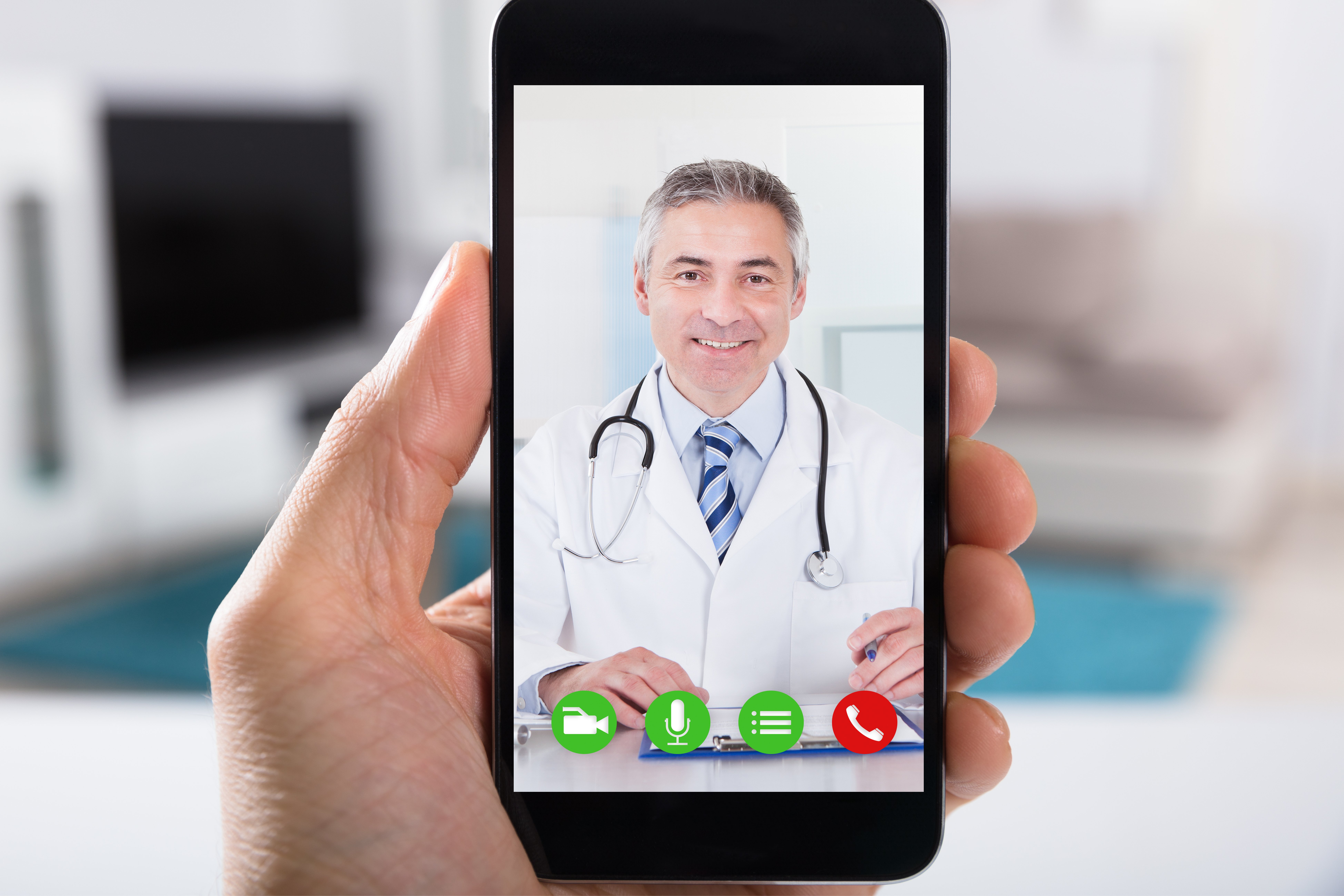 Close-up of video conference with smiling male doctor on smartphone