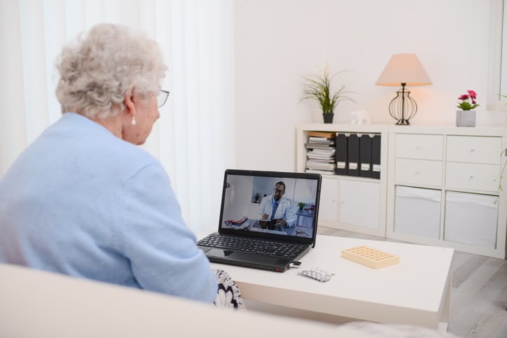 An elderly woman has a virtual visit with her doctor