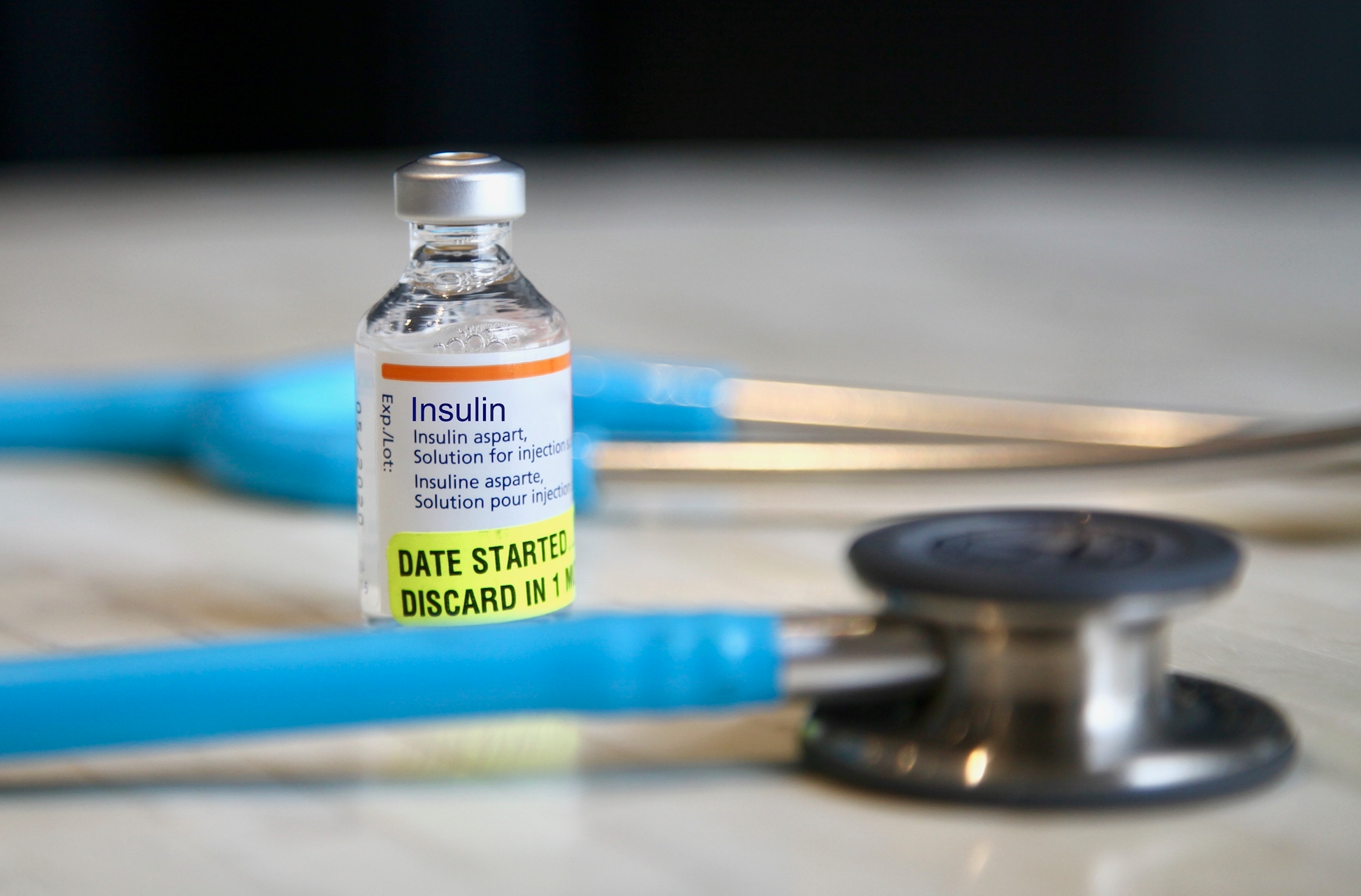 A bottle of insulin surrounded by a stethescope