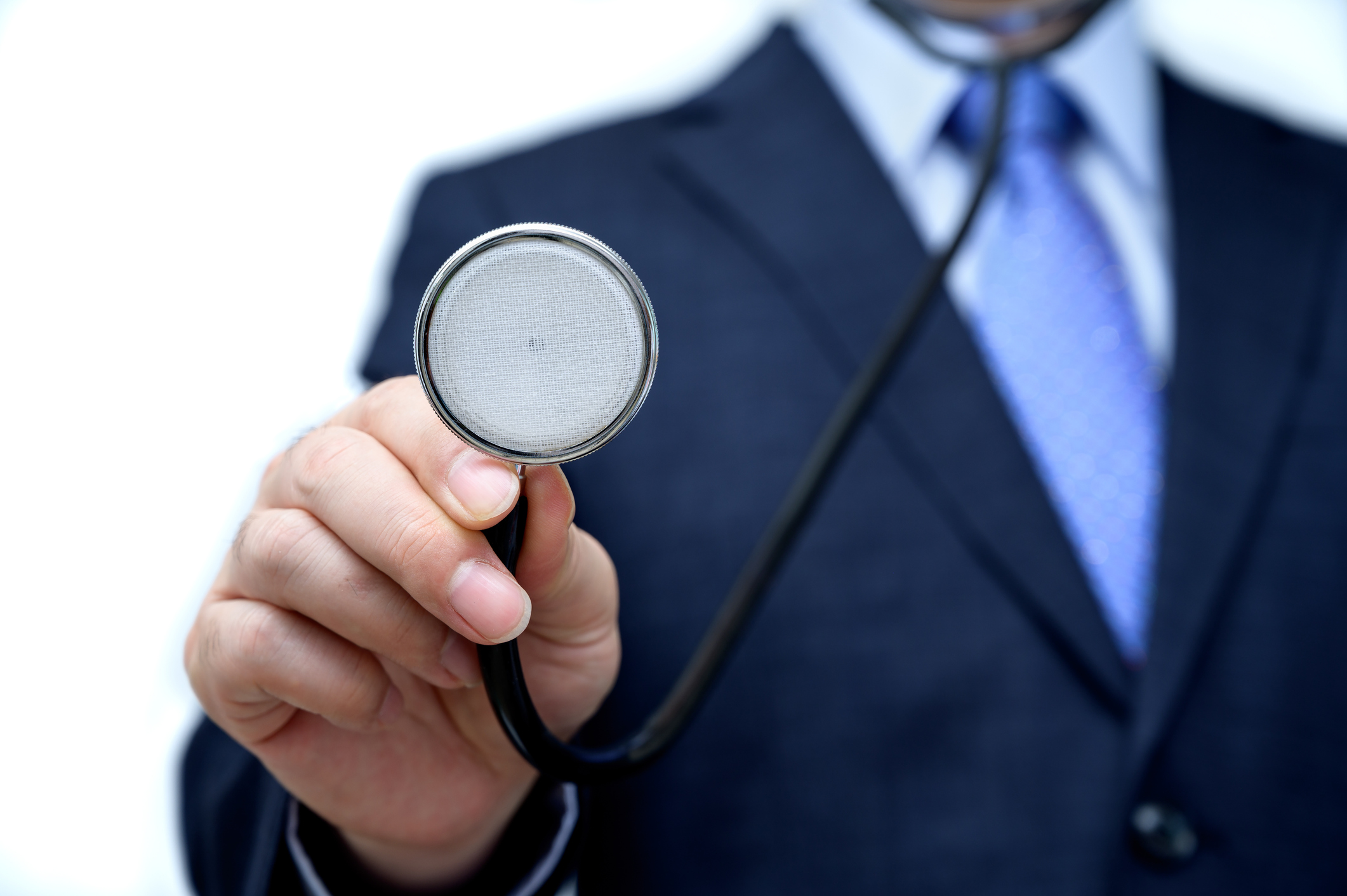 A man in a suit holds a stethoscope