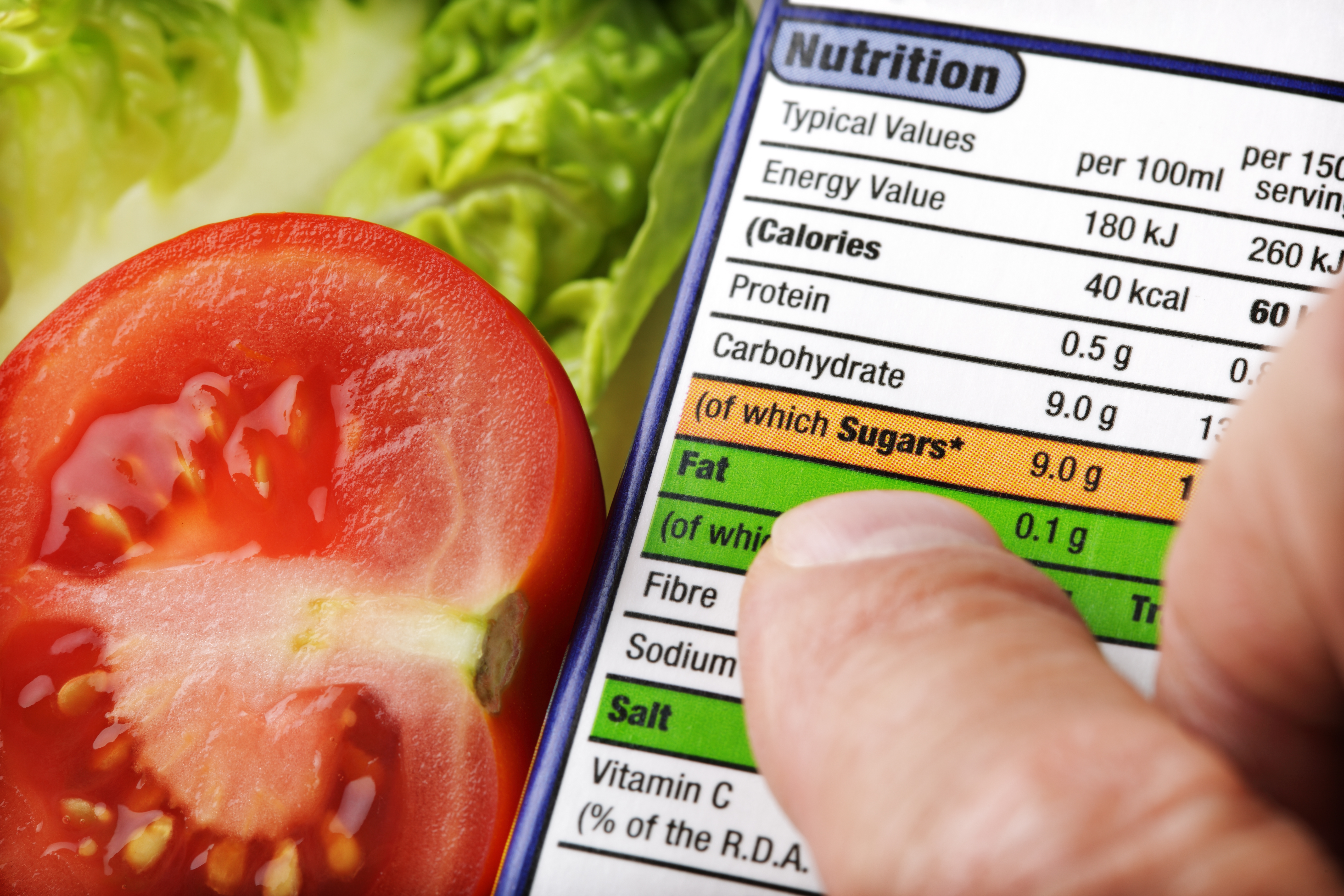 A nutrition label with a salad in the background