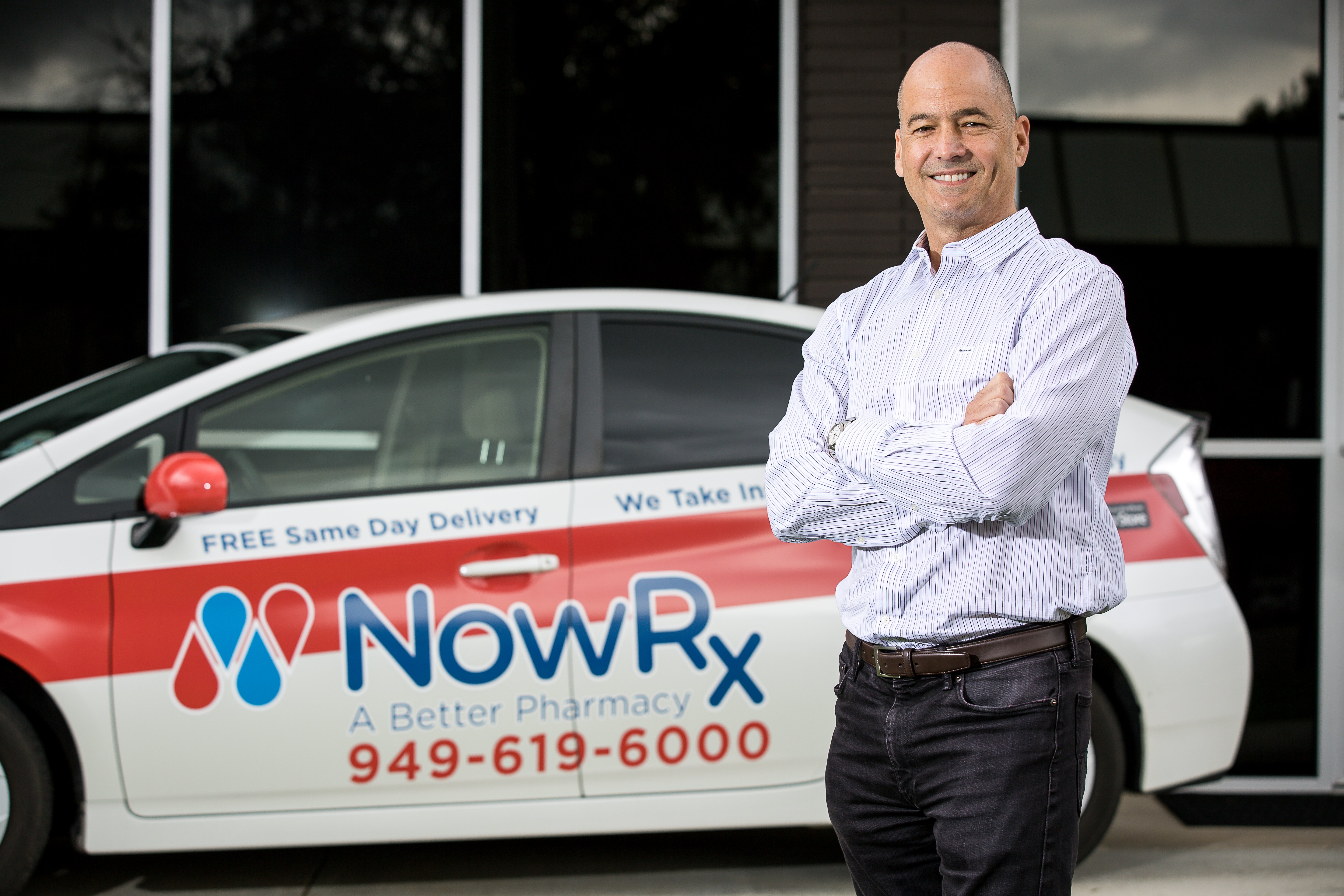 NowRx Founder and CEO Cary Breese stands in front of branded NowRx delivery car