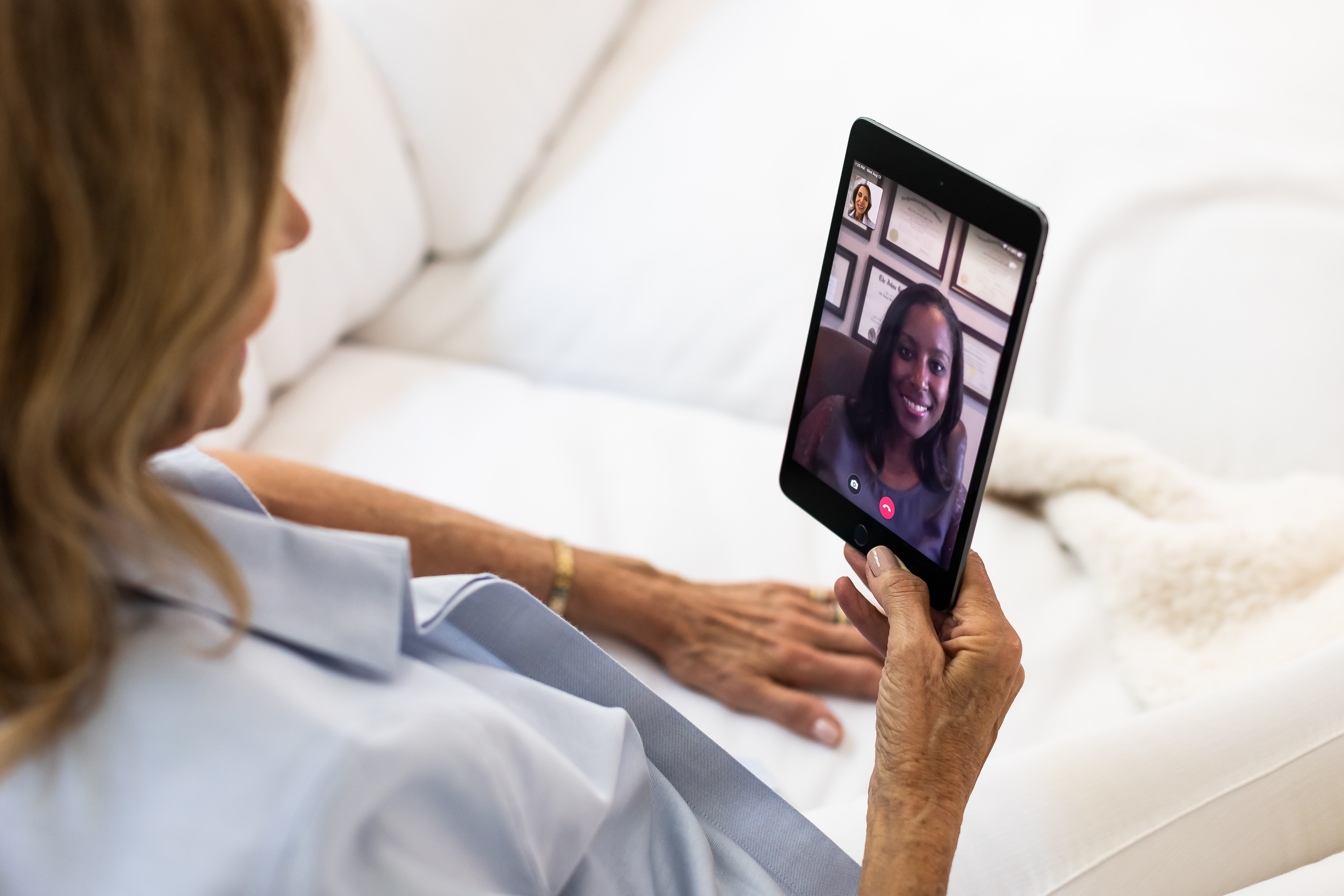 a woman chats with a female doctor during a telehealth video visit