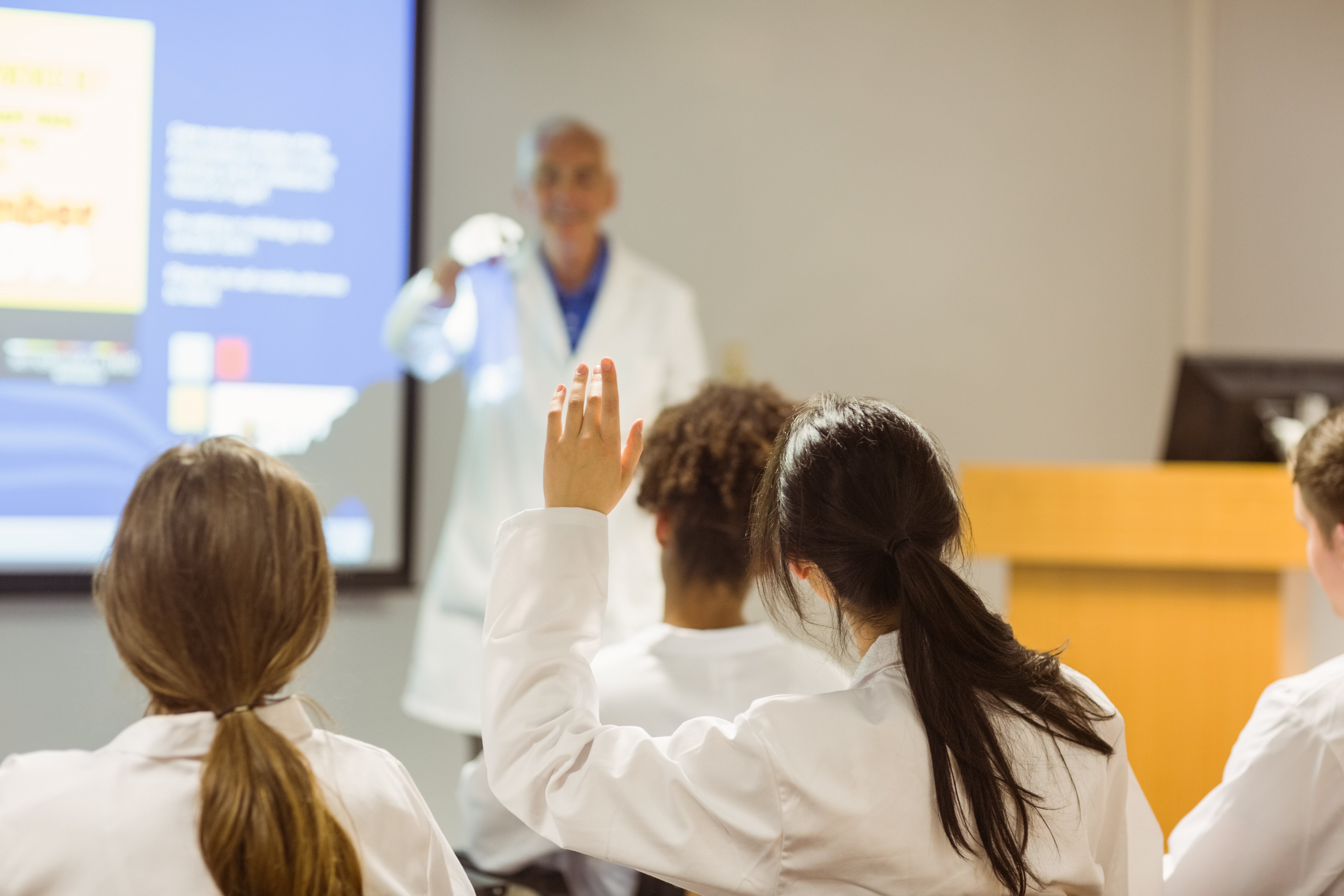 A medical student raising her hand in class