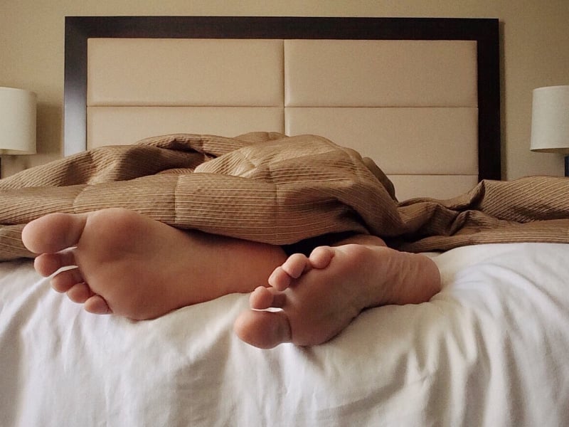 Feet poking out of sheets on bed