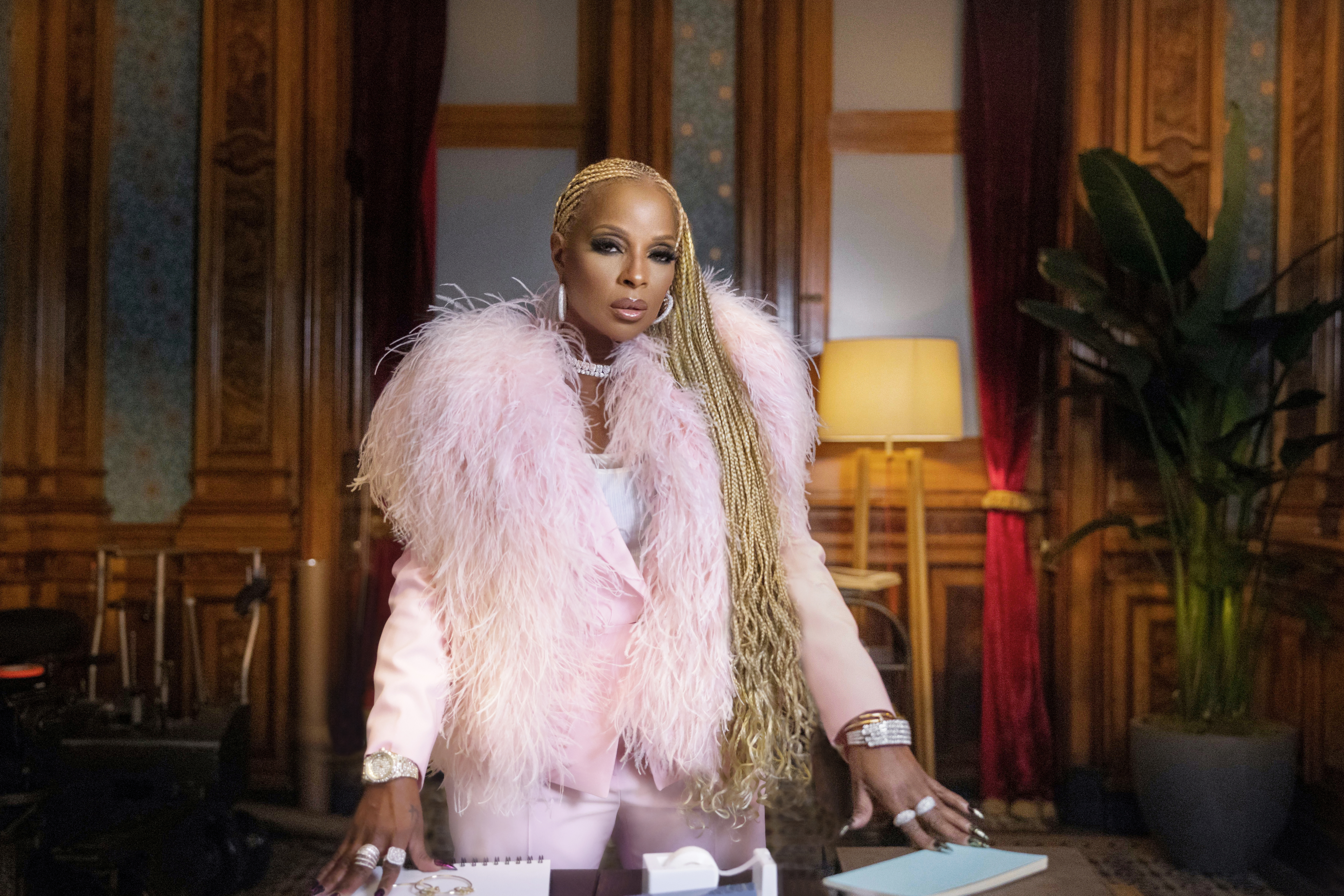 Mary J Blige stands at a table