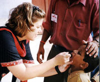 A worker administers a polio vaccine orally in India--Courtesy of CDC, public domain