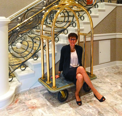 Karen Morris sitting on a hotel luggage cart