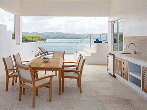 A kitchen table and chairs next to a kitchen counter with a sink