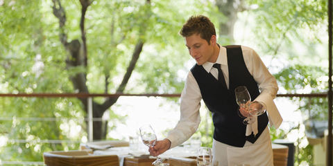 A waiter setting a table