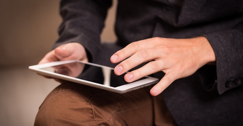 Man tapping finger on tablet computer