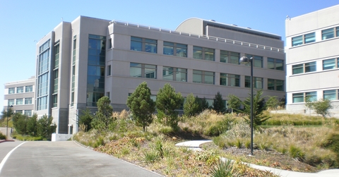 A large, tan building along a road