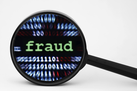 Magnifying glass highlighting the word fraud