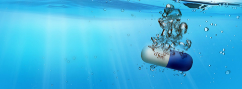 a blue and white pill submerged in water