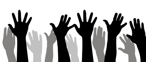 Shadows of multiple hands being raised in the air
