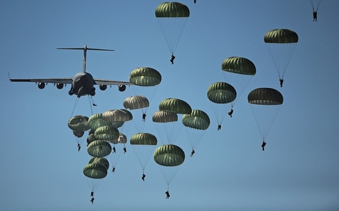 Parachute Many people jumping out of a plane with green parachutes