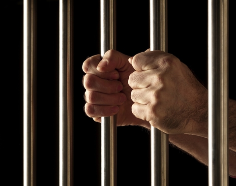 Prison / jail bars Hands clutching prison bars