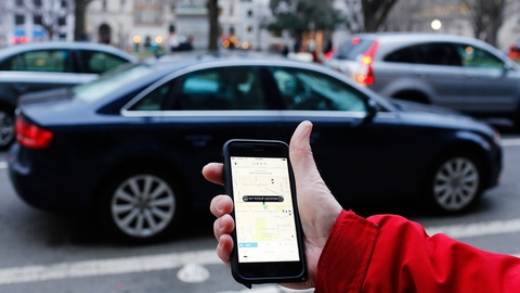 Uber An Uber application is shown as cars drive by in Washington, DC