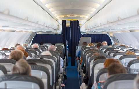 Airplane cabin with passengers - AlxeyPnferov/iStock/Getty Images Plus/Getty Images Airplane cabin with passengers